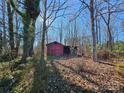 Rustic red barn nestled in a wooded area at 211 Forgotten Ln, Bessemer City, NC 28016