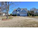 Two-story house with light gray siding, white garage door, and landscaping at 247 Aylesbury Ln, Indian Trail, NC 28079