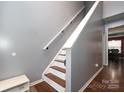 Staircase with hardwood flooring and a simple handrail at 3111 Hendricks Chapel Ln, Charlotte, NC 28216