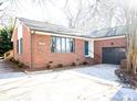 Brick ranch home with teal door, attached garage, and landscaping at 318 S Rhyne St, Dallas, NC 28034