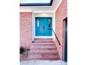 Teal double door entry with brick steps and black railing at 318 S Rhyne St, Dallas, NC 28034