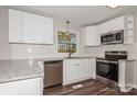 Modern kitchen with white cabinets, granite counters, and stainless steel appliances at 50005 Guy Ln, Norwood, NC 28128