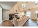 Living room with vaulted ceilings, hardwood floors, fireplace, and comfy sectional sofa at 8708 Sweet Sage Ln, Charlotte, NC 28227