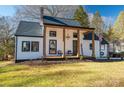 Charming farmhouse-style home with white siding, covered porch, and manicured lawn at 910 S College Ave, Newton, NC 28658