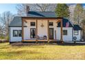 Charming farmhouse-style home with white siding, covered porch, and manicured lawn at 910 S College Ave, Newton, NC 28658