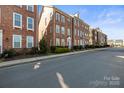 A street view showing classic brick townhomes in a well-planned community at 9223 Belcaro Ln, Charlotte, NC 28273