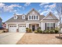 Two-story house with gray siding, three-car garage, and landscaped yard at 12612 Longford Crossing Pl, Huntersville, NC 28078