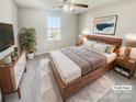 Bright bedroom with a wooden bed frame, dresser, and ceiling fan at 17015 Greenlawn Hills Ct, Charlotte, NC 28213