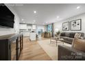 Open concept living room, dining room, and kitchen with light wood flooring and stainless appliances at 2037 Stephens Farm Dr # E, China Grove, NC 28023