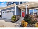 House exterior showcasing gray siding, red front door, and stone accents at 6270 Durango Way, Denver, NC 28037