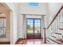 Bright foyer with hardwood floors, staircase, and double doors leading to the outside at 7007 Dowington Dr, Charlotte, NC 28277