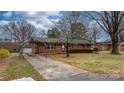 Brick home with carport and long driveway, nestled in a mature, tree-lined neighborhood at 906 16Th Nw St, Conover, NC 28613
