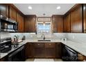 Modern kitchen with dark wood cabinets, granite counters, and stainless steel appliances at 130 Portman Ln, Statesville, NC 28625