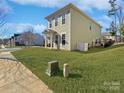 Side view of a two-story house with light green siding and a driveway at 15305 Colonial Park Dr, Huntersville, NC 28078