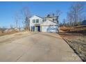 Two-story house with gray siding, a two-car garage, and a long driveway at 162 Four Andrews Dr, Harmony, NC 28634