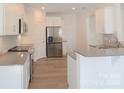 Open concept kitchen with island, stainless steel appliances, and white cabinets at 1819 Teachers House Nw Rd, Concord, NC 28027