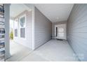 Inviting covered front porch with stone and gray siding at 201 Picasso Trl, Mount Holly, NC 28120