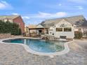 Beautiful backyard pool area with a hot tub, rock waterfall feature, and an inviting patio space perfect for relaxation at 209 Choate Ave, Fort Mill, SC 29708