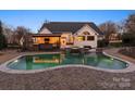 Gorgeous backyard pool featuring a hot tub, stone accents, and covered patio for exceptional outdoor living and entertaining at 209 Choate Ave, Fort Mill, SC 29708