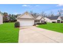 Home with attached garage and long driveway, surrounded by well-maintained landscaping at 2213 Genesis Dr, Monroe, NC 28110