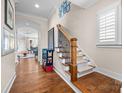 Bright foyer with hardwood floors, staircase, and view into the living room at 2218 Croydon Rd, Charlotte, NC 28207