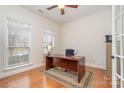 Sunlit home office featuring hardwood floors, large windows, and a classic desk at 3013 Misty Moss Ct, Waxhaw, NC 28173