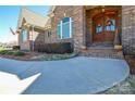 Inviting front entrance with an arched wooden door, flanked by manicured flower beds at 341 Canvasback Rd, Mooresville, NC 28117