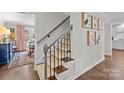 Stylish staircase with patterned runner, wrought iron railing, and artwork on the wall at 4334 Silo Ln, Charlotte, NC 28226