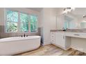 Bright bathroom featuring a soaking tub, vanity, and wood look tile flooring at 4607 Ferguson Cir, Waxhaw, NC 28173