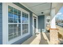 Inviting porch with brick supports and bright white trim around the large windows at 5115 Waterloo Dr, Fort Mill, SC 29708