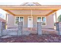 Covered front porch with brick columns and concrete flooring at 604 E Ridge St, Kings Mountain, NC 28086