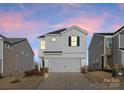 Two-story house with white siding, attached garage, and landscaping at dusk at 642 Citriadora St, Fort Mill, SC 29715