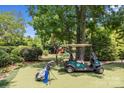 Landscaped backyard with golf cart and putting green at 7213 Fairway Vista Dr, Charlotte, NC 28226