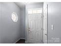 Bright foyer with a white front door, complementary wall paint, and modern light fixture at 9635 Veronica Dr, Charlotte, NC 28215