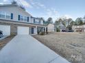 Two-story townhome with gray siding, brick accents, and a two-car garage at 1033 Cedar Village Trl, Salisbury, NC 28147