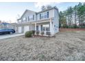 Two-story townhome with gray siding, brick accents, and a two-car garage at 1033 Cedar Village Trl, Salisbury, NC 28147