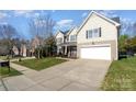 Two-story house with beige siding, a white garage door, and a driveway at 13618 Pacific Echo Dr, Charlotte, NC 28277