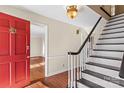 Bright entryway with hardwood floors, staircase, and red door at 140 Kent Rd, Salisbury, NC 28147