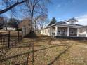 Tan colored house with a wooden fence and grassy yard at 1443 Modena St, Gastonia, NC 28054