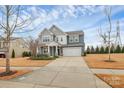 Two-story home with a two-car garage and modern design elements under a partly cloudy sky at 14812 Baytown Ct, Huntersville, NC 28078