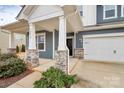 Inviting front entrance with stone accents and a covered porch, creating a warm welcome at 14812 Baytown Ct, Huntersville, NC 28078