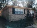 Brick ranch house with black shutters and a walkway at 1825 Herrin Ave, Charlotte, NC 28205