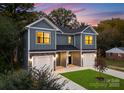 Gray siding duplex with two-car garages and a well manicured lawn at 2025 Tom Sadler Rd, Charlotte, NC 28214