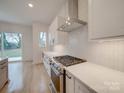 Modern kitchen features white cabinets, quartz countertops and stainless steel appliances at 2039 Renner St, Charlotte, NC 28216