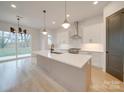 Open concept kitchen with white cabinets, quartz countertops and large island at 2039 Renner St, Charlotte, NC 28216