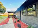 Stylish home featuring new windows and professional landscaping with red mulch, enhancing curb appeal at 3027 Remington St, Charlotte, NC 28216