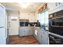 Eat-in kitchen with gray cabinets and wood flooring at 400 Charles St, Spencer, NC 28159