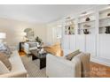 Spacious living room featuring a built-in shelving unit and hardwood floors at 6412 Wheeler Dr, Charlotte, NC 28211