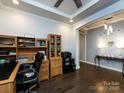 Well-lit home office with built-in shelves, desk and hardwood flooring at 8177 Breton Way, Harrisburg, NC 28075