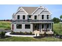 Two-story gray house with a metal roof, dark brown garage doors, and landscaping at Lot 113 Mayes Meadow Dr # Covington, Cornelius, NC 28078